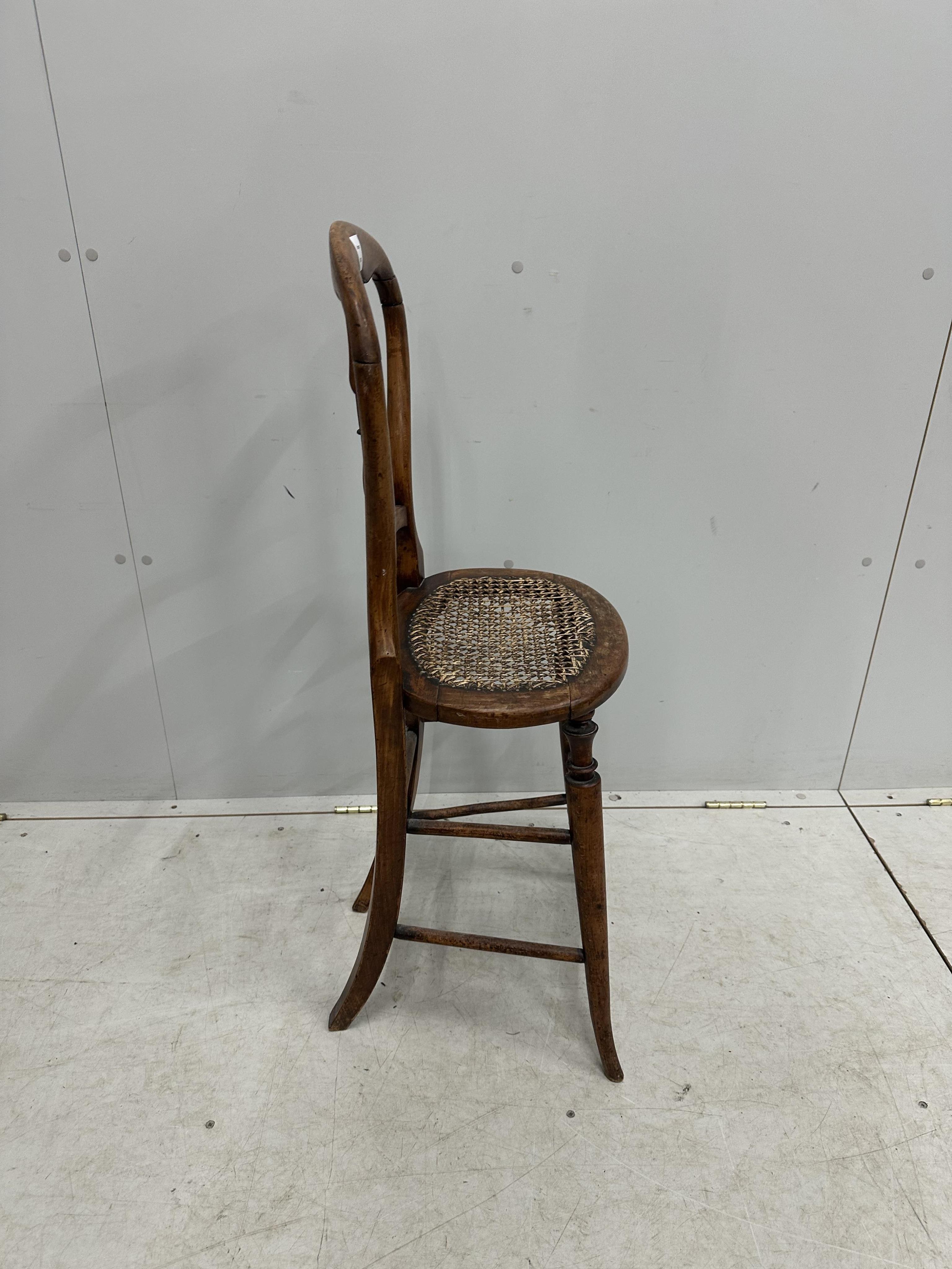 A Victorian beech cane seat correction chair, height 96cm. Condition - fair